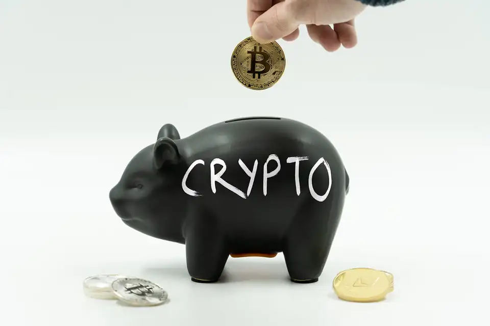 Alcancía negra con la palabra «crypto» y una moneda de Bitcoin